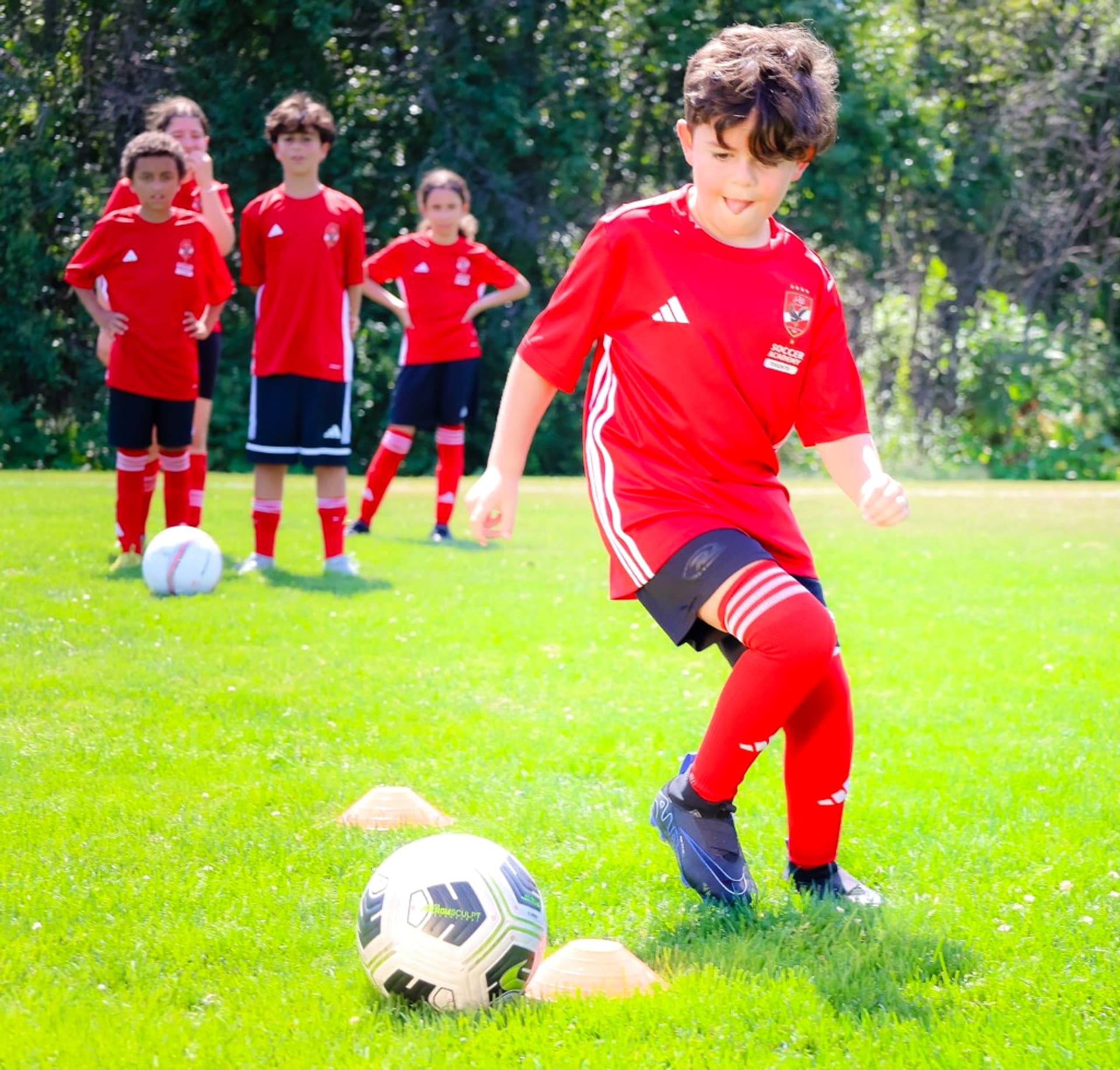 Child dribbling through training cones
